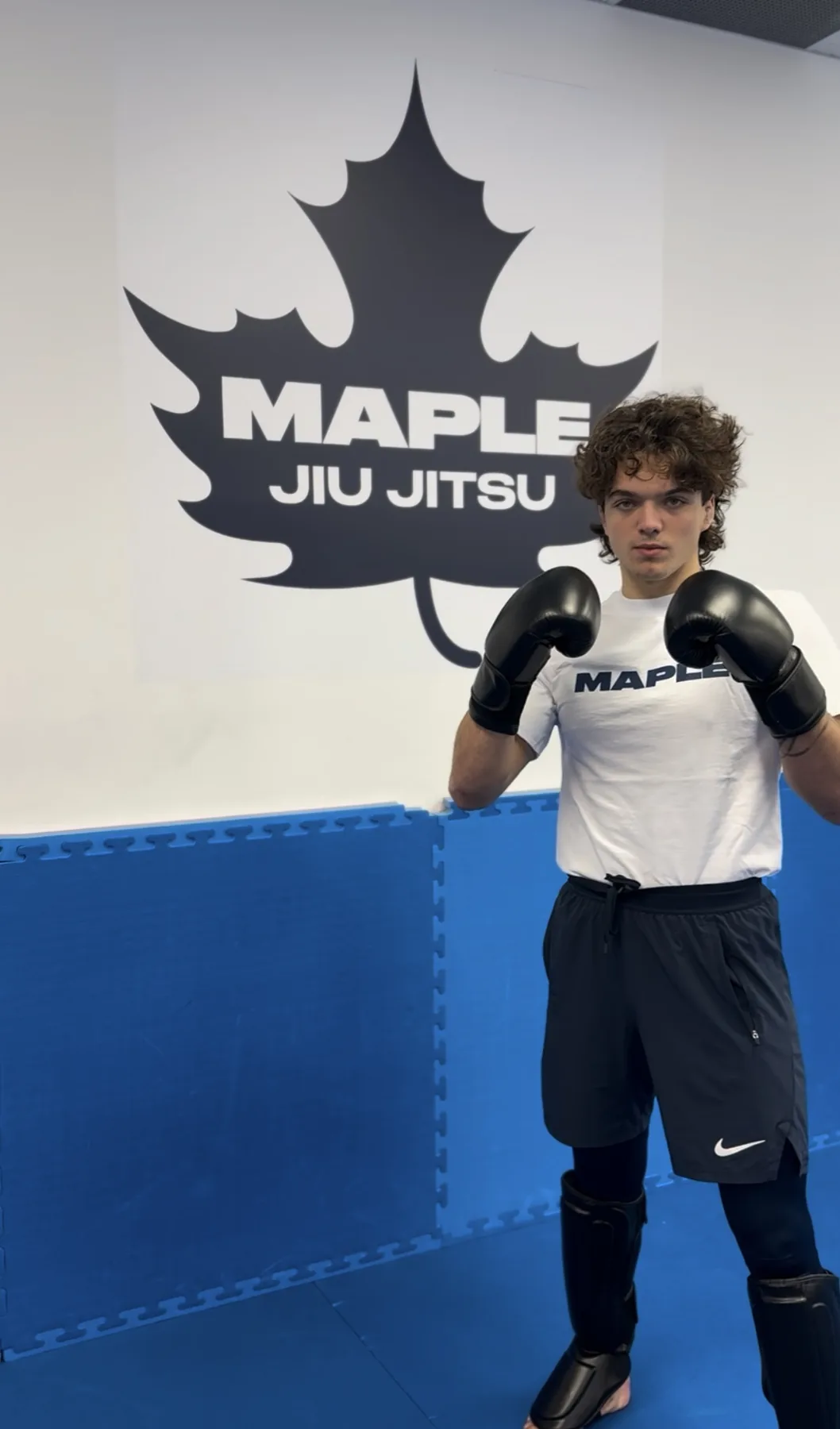 A Muay Thai student in gloves and shin guards at Maple Jiu-Jitsu Academy in Maple, Ontario
