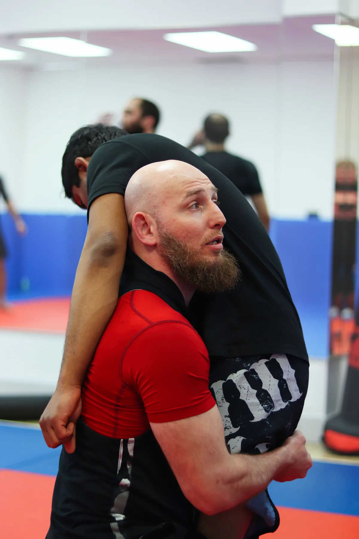 A wrestler securing a body lock during freestyle wrestling training at Maple Jiu-Jitsu Academy